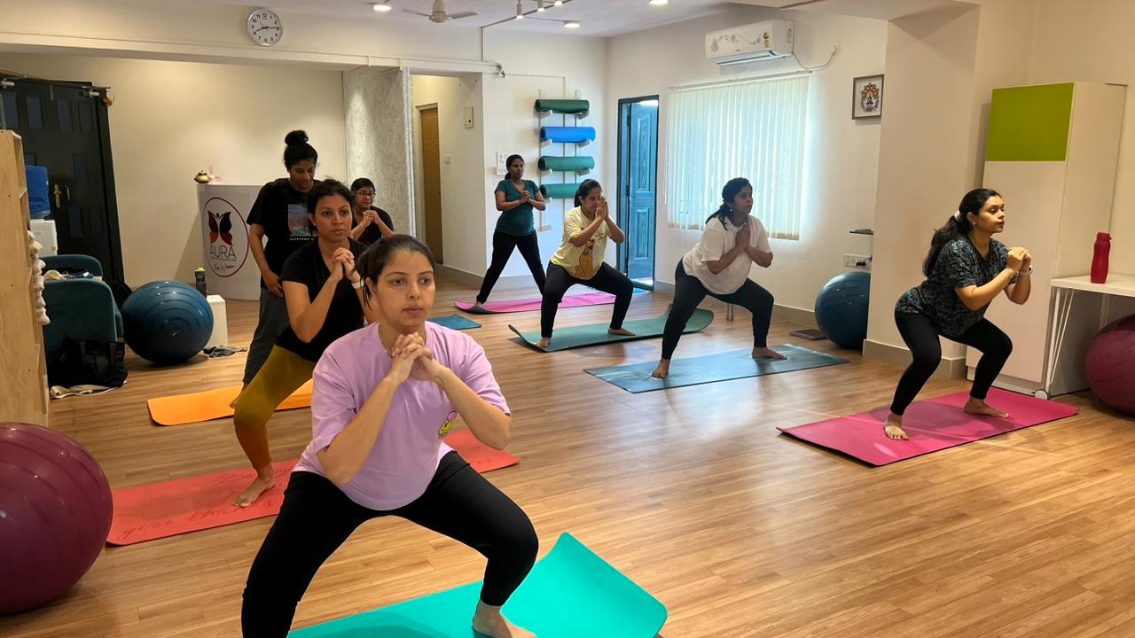 Women practicing yoga at Aura, fostering a healthy and mindful prenatal fitness routine.